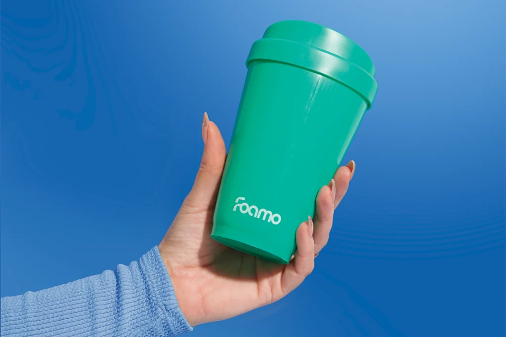 Hand holding a spearmint FOAMO coffee cup